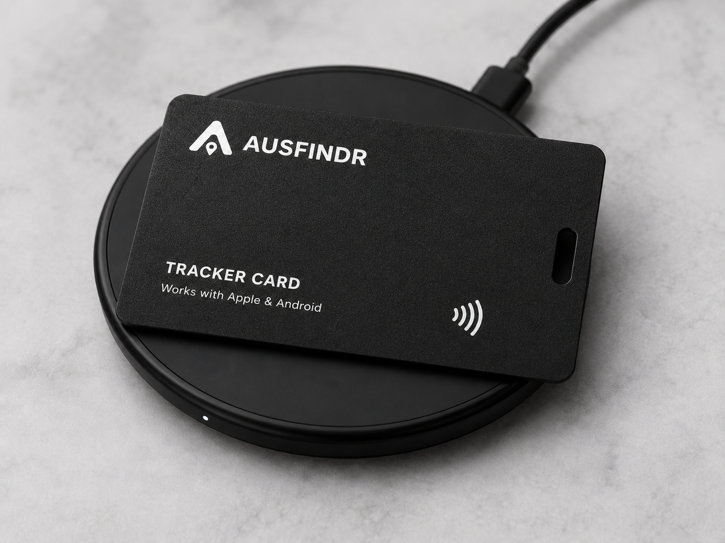 Black Ausfinder tracker card on a charger