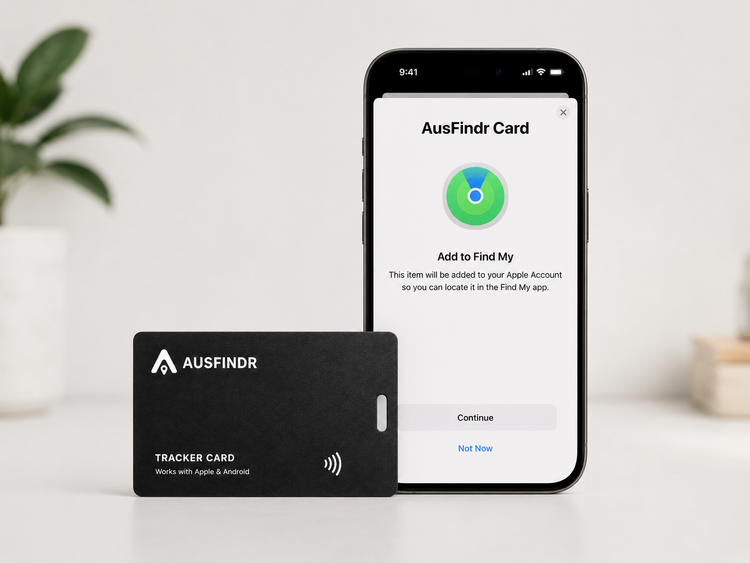 Phone displaying the Ausfinder app with a black tracker card on a white surface.